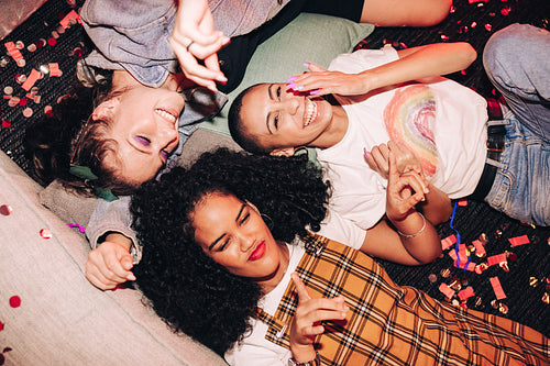 High angle view of happy friends lying on the floor at a party