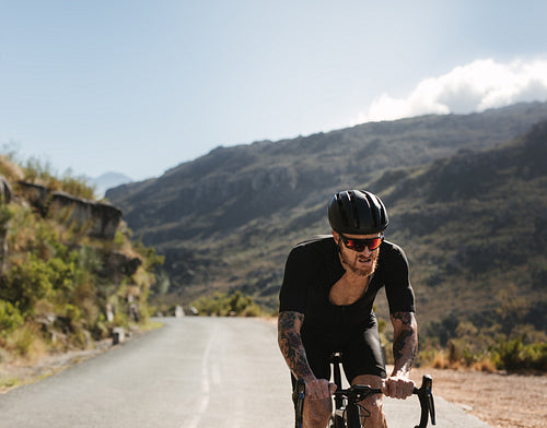 Cyclist putting effort while training on mountain roads
