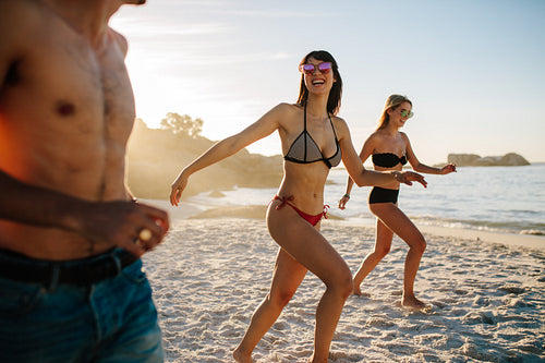 Happy friends running on the beach
