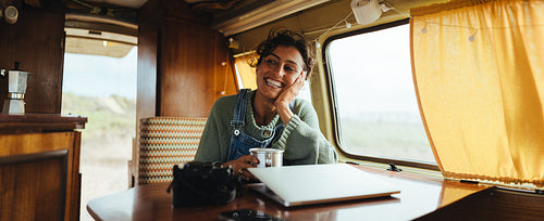 Cozy traveler in a camper van enjoying tea and smiles