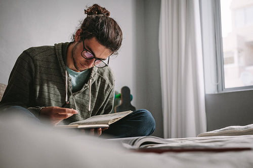 Student sitting on bed and studying