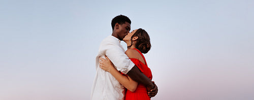 Interracial couple kissing outdoors