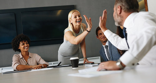 Successful teamwork in an office: Business colleagues celebrating with a high five