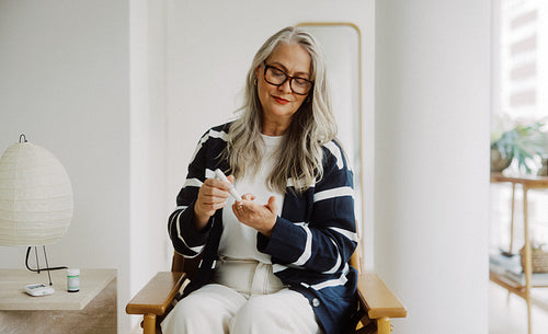 Senior woman testing blood glucose at home