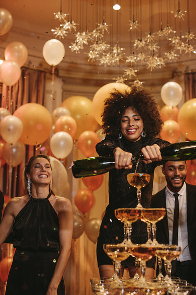Woman filling pyramid of champagne at new years eve
