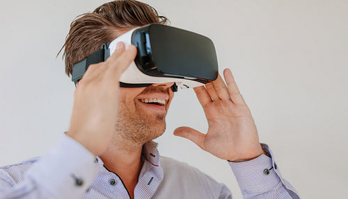 Happy young man wearing virtual reality goggle
