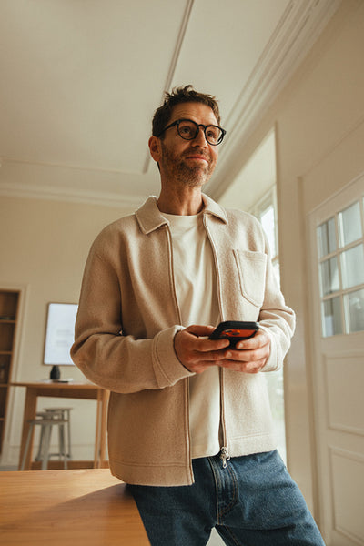 Mobile phone use in the office, man on smartphone in modern workspace
