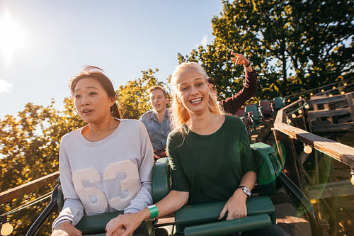 Happy young people riding a roller coaster