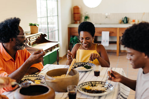 Family enjoying traditional brazilian meal together in a happy home kitchen