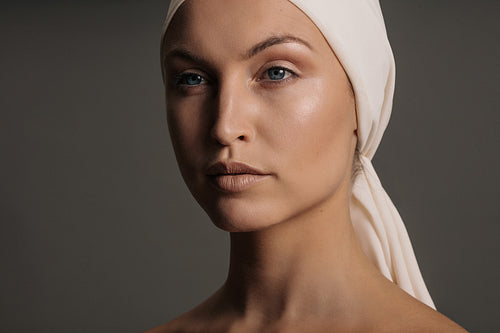 Young woman with head scarf looking away