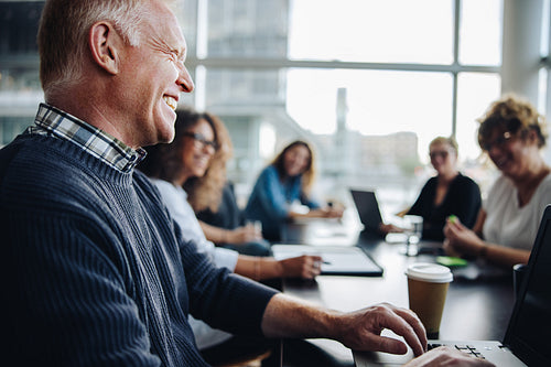 Manager discussing work with employees in meeting room