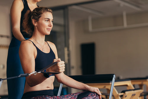 Woman at a pilates gym pulling stretch bands