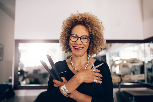 Female hairdresser at the salon holding hairdressing accessories