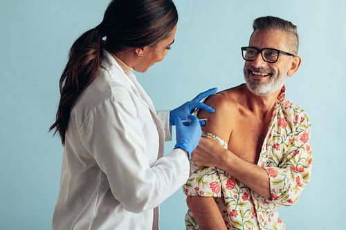 Doctor giving flu shot to patient