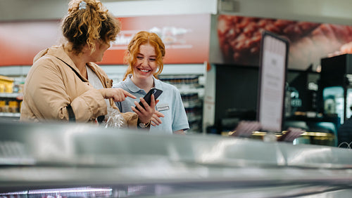 Friendly employee helping customer at the supermarket