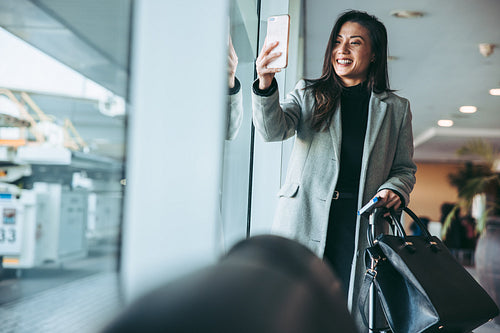 Woman taking selfie at the airport departure gate