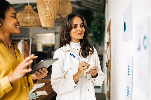 Business women working together in an office, brainstorming ideas for their startup