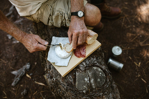 Senior man having food at campsite