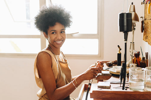 African woman at her jewelry making workshop