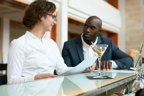 Cocktail on counter with two businesspeople in background