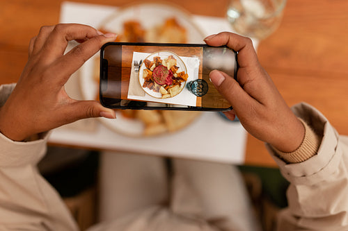 Blogger taking a picture of her food in a restaurant