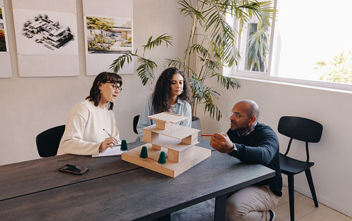 Architects discussing an upcoming project at a meeting with a model