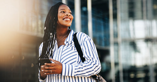 Pensive business woman looking away with a smile while commuting in the city