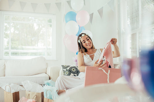 Female opening gifts at baby shower party