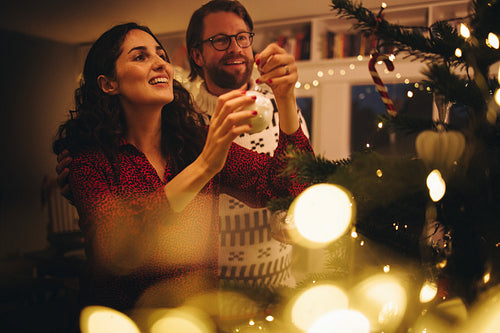 Couple decorating Christmas tree