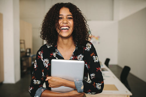 Businesswoman with a laptop in hand standing in office