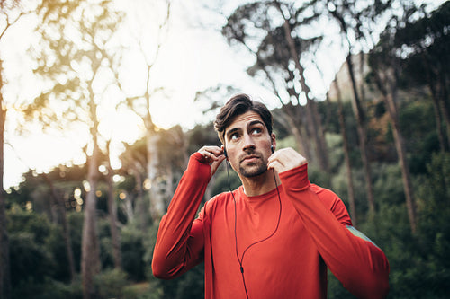 Runner wearing earphones during workout in a park