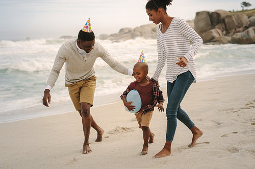 Family running along the beach