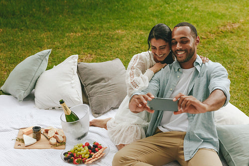 Loving couple taking selfie on picnic