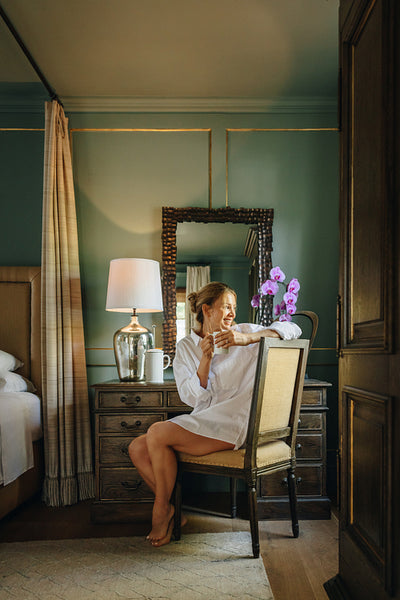 Happy young woman sitting in a luxury hotel room