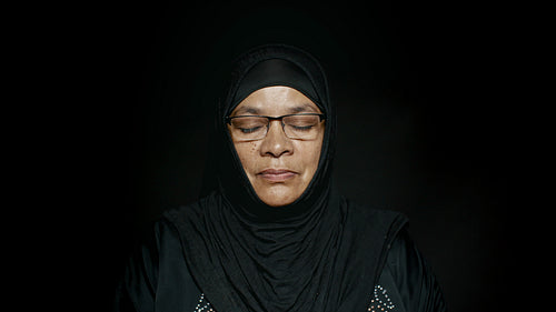 Islamic woman praying with eyes closed