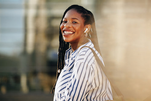 Happy young business woman smiling at the camera while traveling to work in the city