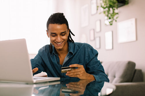 Cheerful young man shopping online
