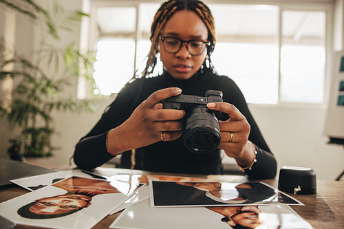 Photographer holding a dslr camera in her home office