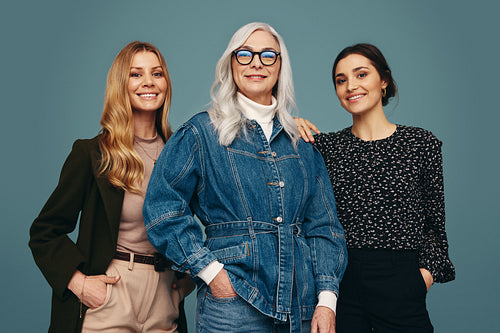Happy trio of women standing together in a studio