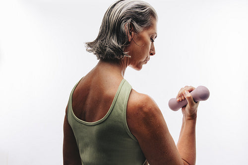 Woman lifting dumbbell in studio workout