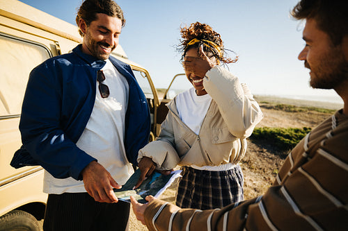 Friends choosing their next stop on a spontaneous road trip
