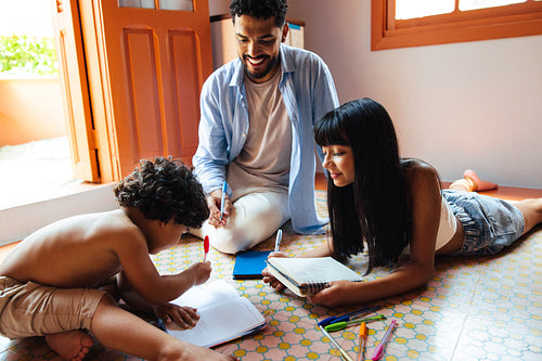 Father and children spending quality time together drawing and learning at home