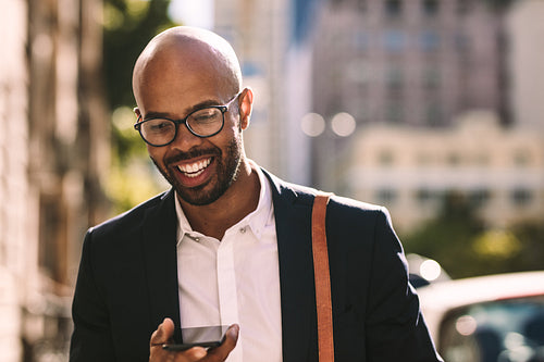 Businessman commuting with a mobile phone outdoors