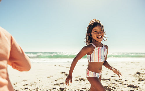 Playful little girl having fun at the beach
