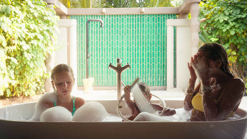 Mother and children enjoy a joyful bubble bath and shower at their luxury resort villa