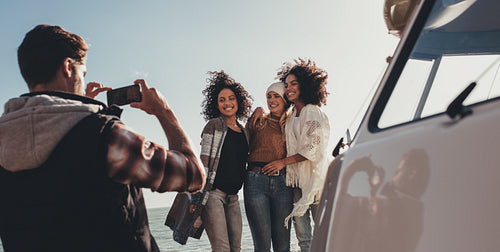 Group of young people on road trip taking pictures