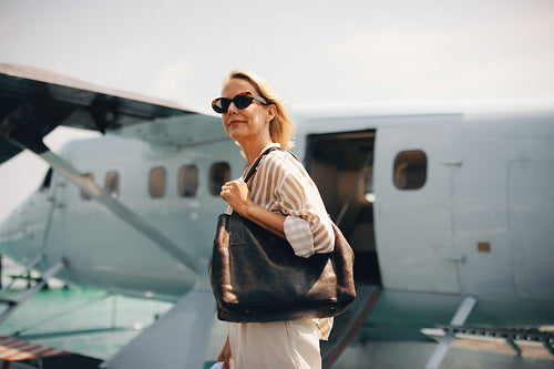Stylish traveler arriving by private plane at a tropical destination