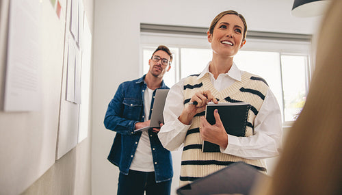 Business colleagues standing next to a white board in a creative office