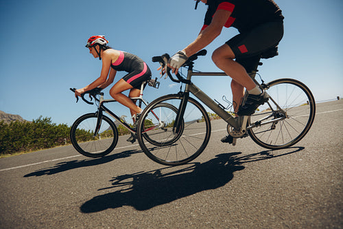 Cyclist riding bicycles down hill on country road
