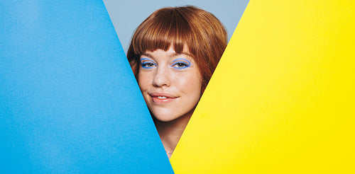 Woman with ginger hair standing with geometric shapes